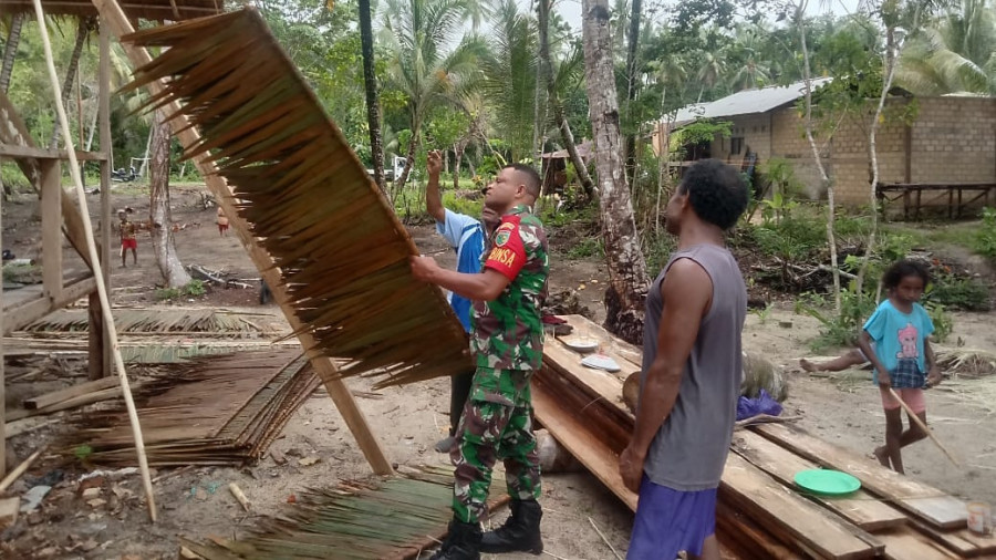 Babinsa Menunjukkan Kepedulian dengan Membantu Masyarakat dalam Membangun Rumah Adat