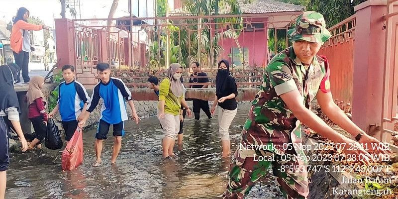 Babinsa Koramil Sananwetan dan Warga Masyarakat Bersatu untuk Melakukan Kerja Bakti Pembersihan Sungai