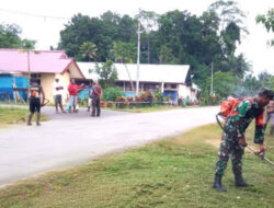 Babinsa Membantu Membersihkan Rumput dan Sampah di Bahu Jalan untuk Menciptakan Kemanunggalan TNI-Rakyat