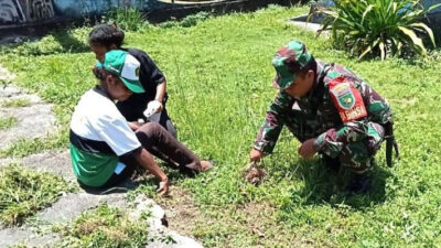 Babinsa Biak Timur Ikut Warga Membersihkan Lingkungan di Tugu Injil Masuk